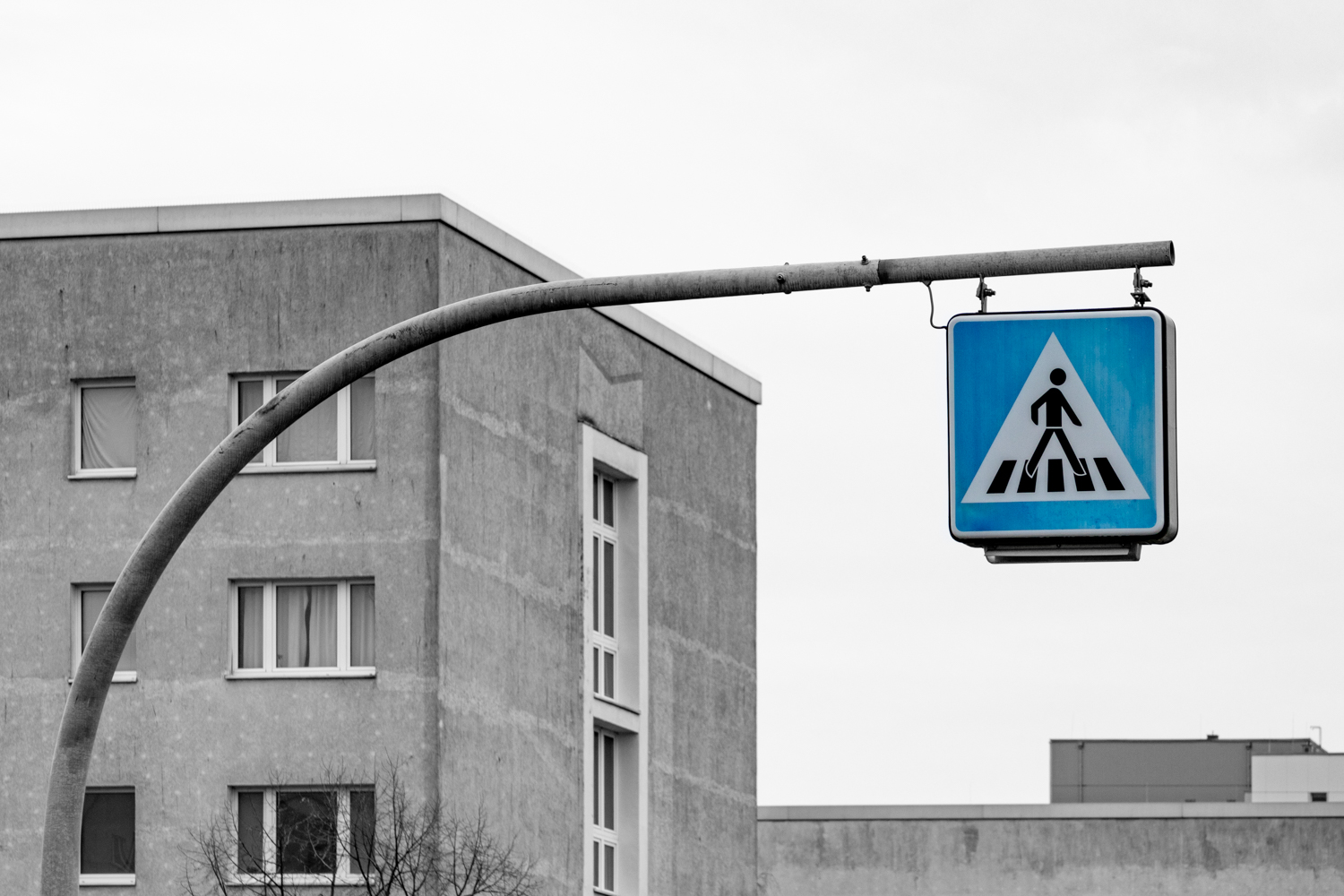 Architekturfotografie eines plattenbaus mit Fußgaengerueberweg im Vordergrund