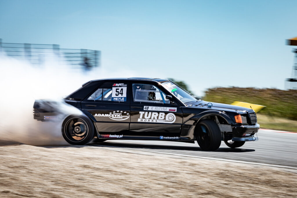 Architekturfotografie eines schwarzen Autos im Drift